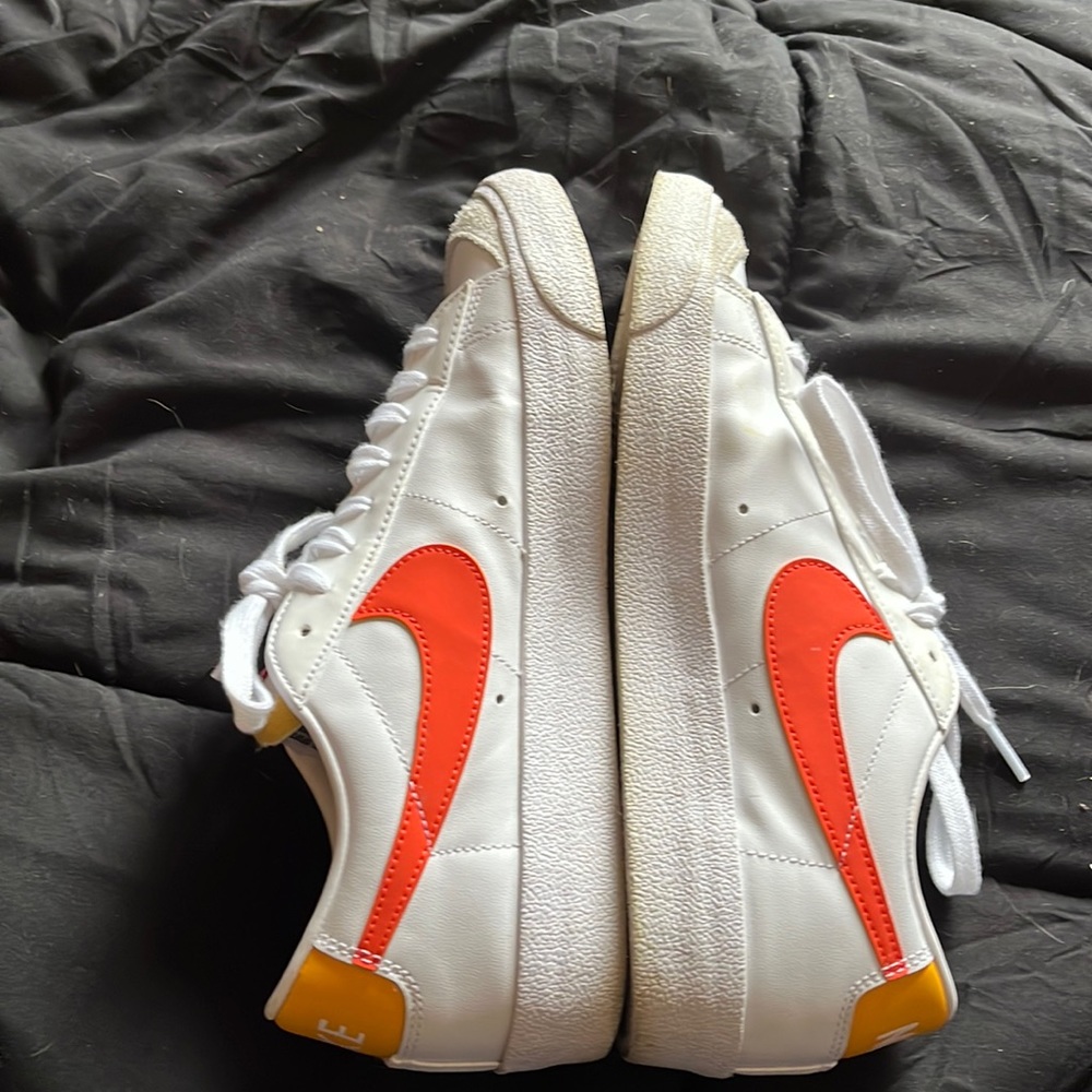 Low top Nike blazers with orange swoosh.